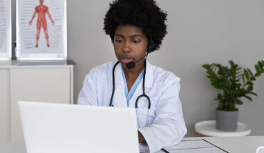 Online Healthcare Guide 2025 - Professional female doctor wearing headset and white lab coat conducting a virtual telehealth consultation via laptop