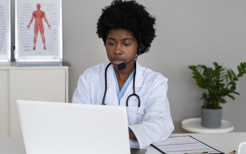 Online Healthcare Guide 2025 - Professional female doctor wearing headset and white lab coat conducting a virtual telehealth consultation via laptop