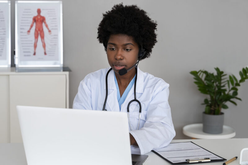 Online Healthcare Guide 2025 - Professional female doctor wearing headset and white lab coat conducting a virtual telehealth consultation via laptop